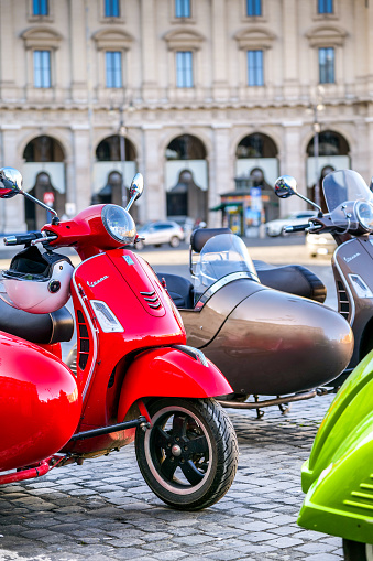 Rome, Italy, November 11 -- Some lovely and characteristic Vespa sidecar scooters parked in Piazza della Repubblica on the edge of the Rione Monti (Monti district) formerly called the Suburra district, in the historic heart of Rome. Designed starting in 1946 by the Italian motorcycle brand Piaggio, the Vespa has become one of the ever-fashionable symbols of industrial culture and Italian design in the world. In 1980 the historic center of Rome was declared a World Heritage Site by Unesco. Image in high definition format.