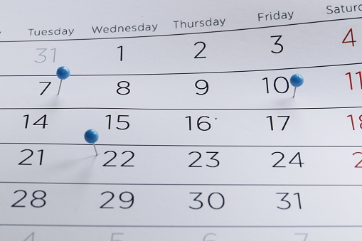 Many different pins on the calendar close-up. Important date. Place for text. Planning concept.