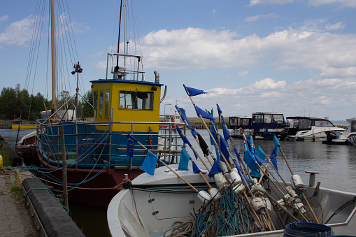 Fishing port and marina in Kąty Rybackie in Poland, the Pomeranian Voivodeship, Nowy Dwór County, Sztutowo commune. Fishing boats, fishing equipment, yachts and tourist boats in the port. Boats moored at the port quay.