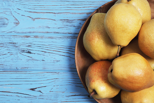 Sweet yellow pears on a blue wooden background. Pears harvest