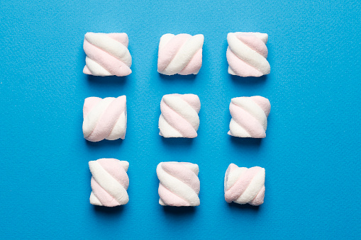 Abstract composition of marshmallows on a blue background. Tov view