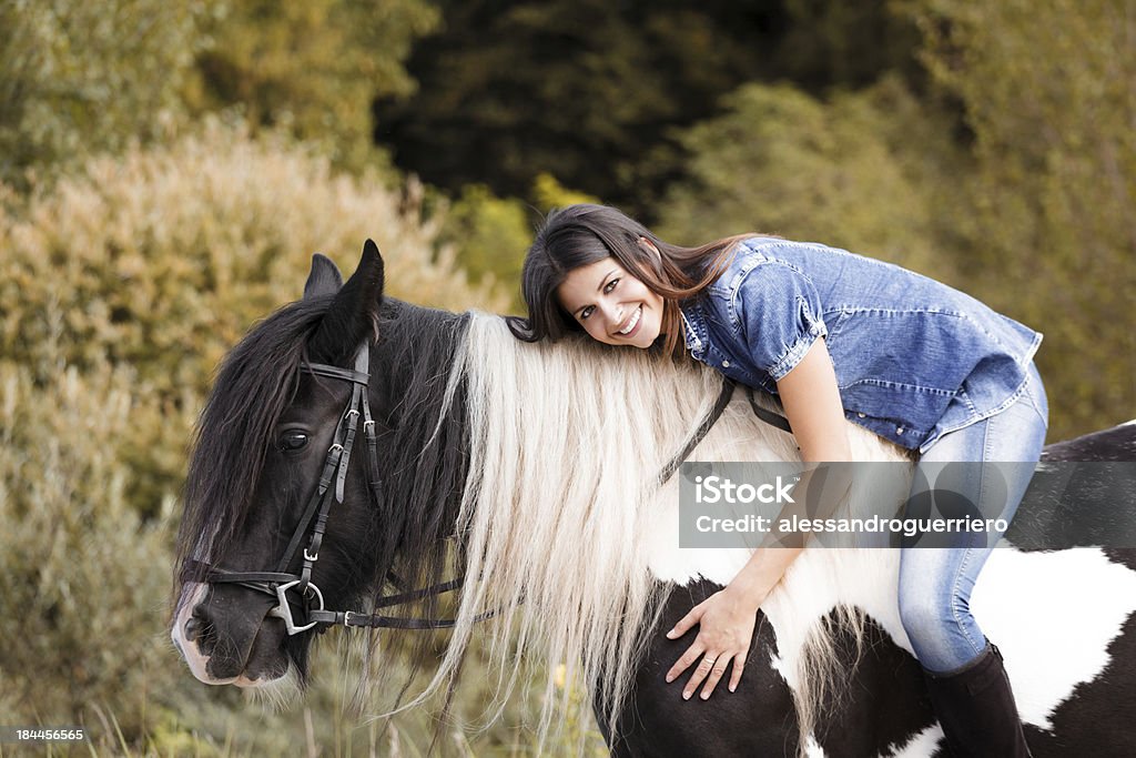 portrait of attractive young female rider embracing her horse portrait of attractive young female rider embracing her horse and looking at camera Adult Stock Photo