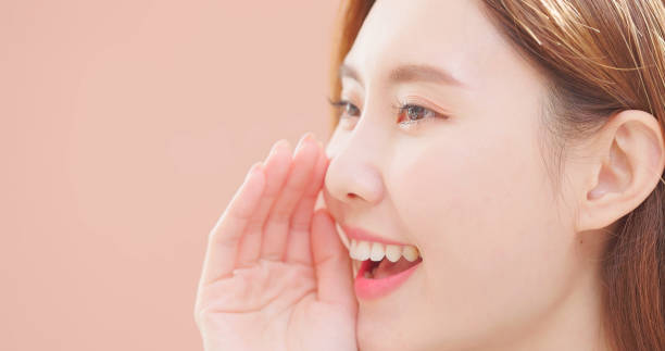 Closeup  of asian beauty whispers - she is smiling with happiness and sharing secret