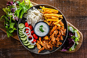 Kebab served with rice, french fries and vegetables