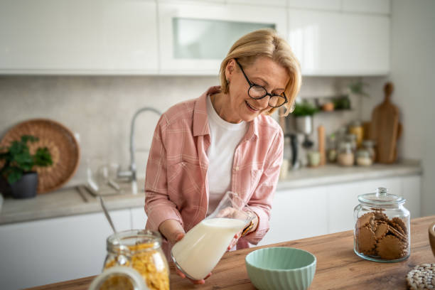 istock An elderly woman prepares a healthy breakfast, cornflakes with milk 1844602966
