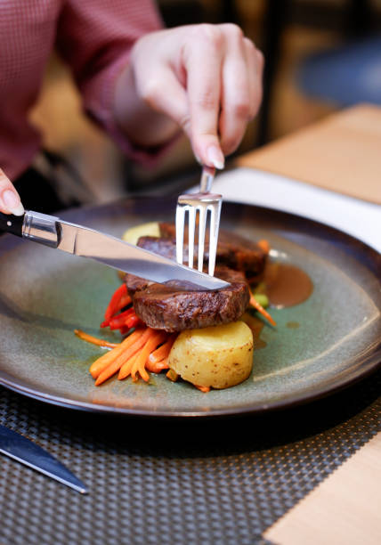 istock woman is cutting veal medallion 1844608829