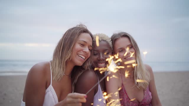 Beauty women lighting sparklers at the beach