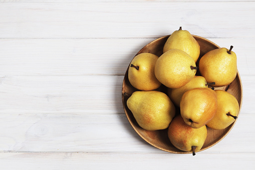 Yellow sweet pears on a white wooden background. Copy space. Design elements.