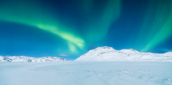 Aurora Borealis. Panoramic landscape. Northern lights and starry skies. Nature. Scandinavian countries. Landscape in winter time. Photo for background and wallpaper.