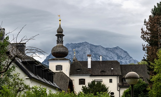 Gmunden, Austria, July 7, 2022: View of the former country castle Landschloss Ort, where the state forestry school and a forestry training center were located until recently. The building, seen from a public park, is currently empty. In the background is the Traunstein mount.