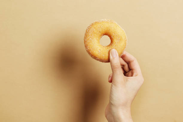 istock Woman holding delicious donut on color background 1844679821