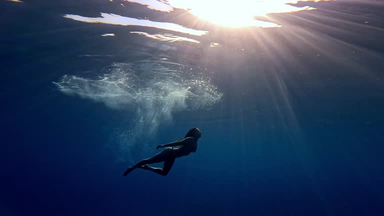 Attractive mid adult woman diving in the sea