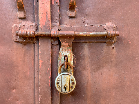 Close-up image of a door with rusted handle and lock