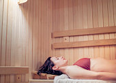 Woman relaxing in a Finnish wooden sauna
