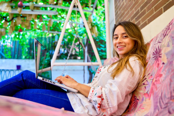 istock young female student working on her laptop at home looking at the camera 1844794193