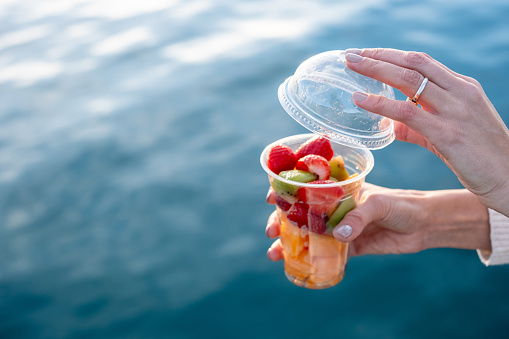 Plastic can container with assorted fresh fruits. Transparent plastic takeaway can container with open dome.