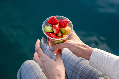 Plastic can container with assorted fresh fruits. Transparent plastic takeaway can container with open dome.