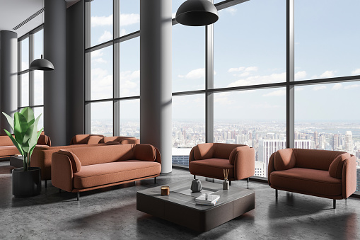 Dark business lobby interior with brown sofa and armchairs, side view coffee table with decoration on grey concrete floor. Panoramic window on New York skyscrapers. 3D rendering