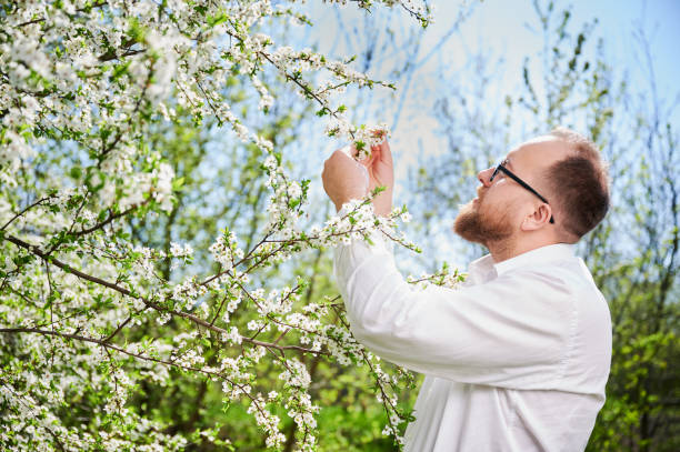 istock Man allergic enjoying after treatment from seasonal allergy in front of blossom tree at spring. 1844856463