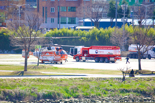 Ulsan, South Korea - June 21, 2023: A Korean firefighting helicopter is captured mid-refueling at Taehwa Park, highlighting the critical role of aerial support in emergency services.