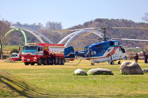 Ulsan, South Korea - June 21, 2023: A Korean firefighting helicopter is captured mid-refueling at Taehwa Park, highlighting the critical role of aerial support in emergency services.
