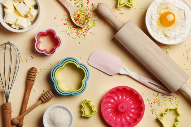 istock Baking utensils and ingredients. Colorful silicone cooking utensils, rolling pin, sugar sprinkling, whisk with cookie mold on a colored background. Baking concept. Place for text. Easter concept. 1844927853