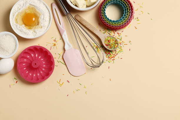 istock Baking utensils and ingredients. Colorful silicone cooking utensils, rolling pin, sugar sprinkling, whisk with cookie mold on a colored background. Baking concept. Place for text. Easter concept. 1844928372