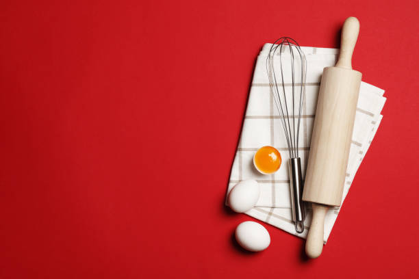 istock Baking utensils and ingredients.  Rolling pin, sugar sprinkling, whisk with cookie mold on a red background. Baking concept. Place for text. 1844943130