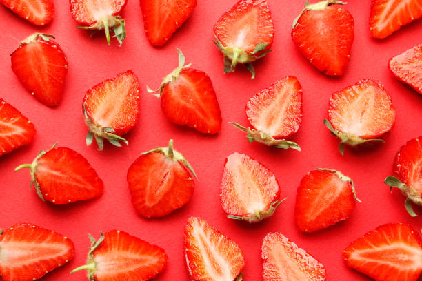 istock Ripe juicy strawberries on a red background. pattern. Creative summer background composition with strawberry slices. Minimal fruit concept. 1844950649