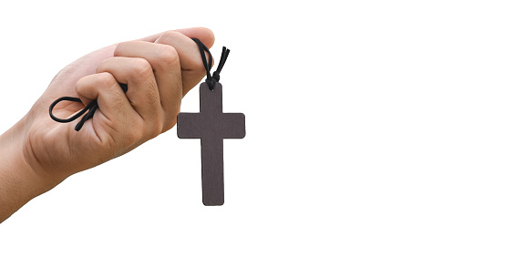 Wooden cross rosary holding in hand to new believer isolated on white background with clipping paths.
