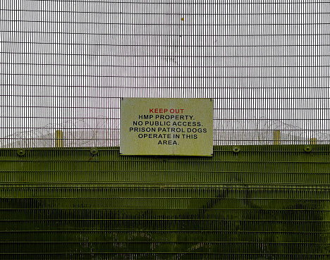 A keep out sign on a security fence at Norwich Prison