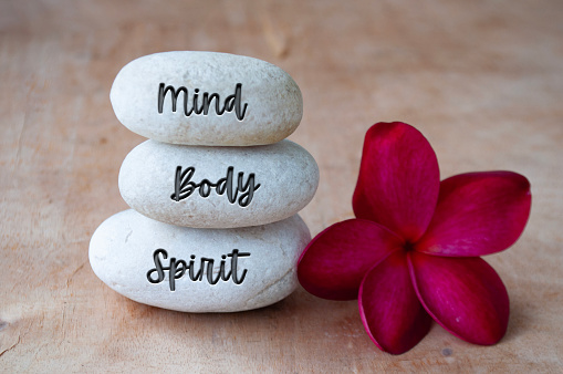 Mind, Body and Soul text engraved on white zen stones. Meditation and spa concept