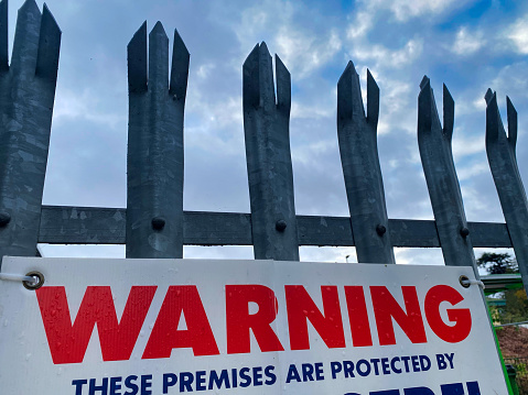 A photograph of a warning sign about private premises being protected in Devon, UK.