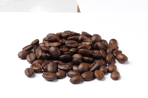 Heap of brown roasted coffee beans in burlap bags isolated on white background. fresh coffee beans concept