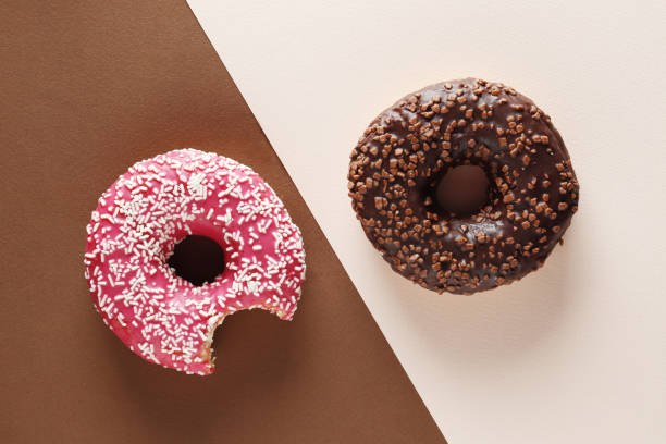 istock Donuts with icing on pink background. Sweet donuts. Donuts background . Eaten donut. 1845055705