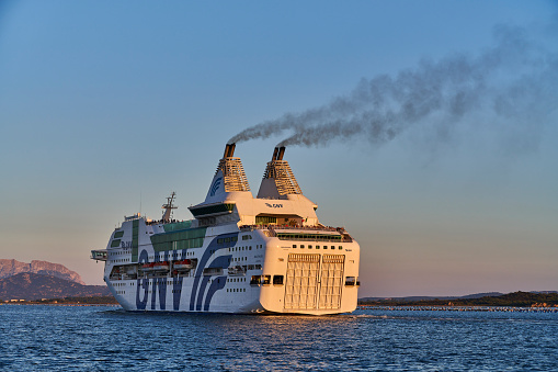Olbia, Italy - October 02, 2023: the ferry GNV (Grandi Navi Veloci) Rhapsody departing from Olbia touristic docks at sunset.