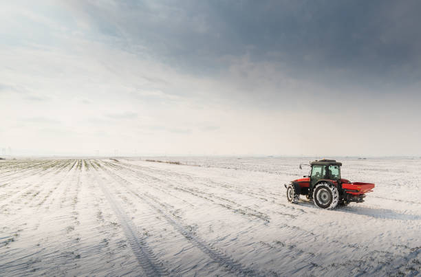 istock Farmer with tractor seeding - sowing crops at agricultural fields in winter 1845077171