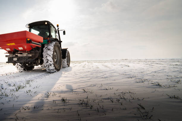 istock Farmer with tractor seeding - sowing crops at agricultural fields in winter 1845077180