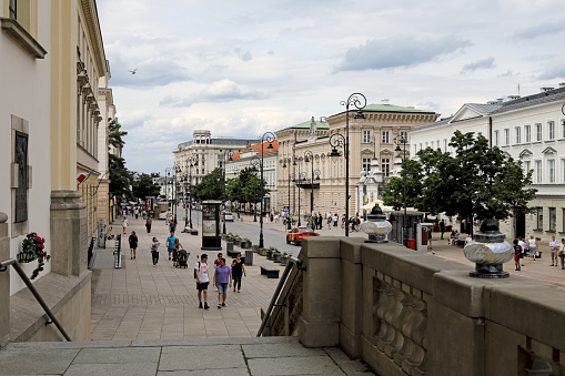 Warsaw, Poland - July 19, 2023: There are palatial buildings along Krakowskie Przedmiescie Street. Many people stroll along this famous street in the city centre.
