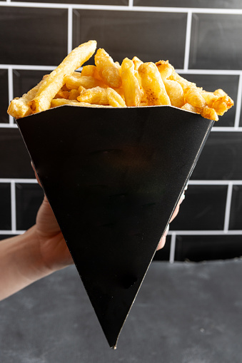 takeaway french fries cone on black background