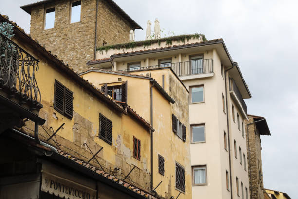 Florence, Italy - April 14, 2023: Details of the historic buildings on the bridge known as the Ponte Vecchio, as seen on a cloudy day.