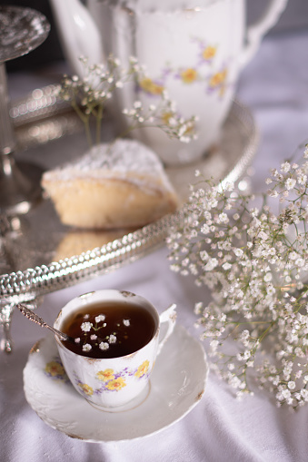 white still life with cheesecake gypsophila and cup of tea, light and airy, High quality photo,table setting for tea drinking in the English style
