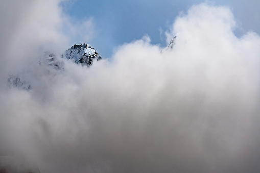 A snowy mountain top covered by dark clouds in the high himalayas of Nepal in Kanchenjunga region