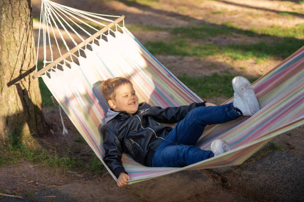 istock Summer active leisure for kids. Child swinging and relaxing in hammock. 1845207283