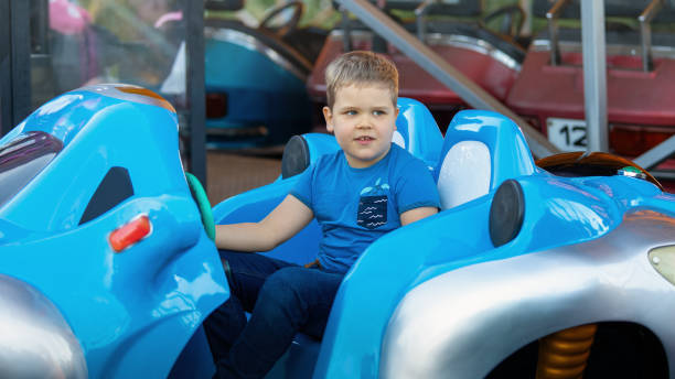istock Little boy having fun riding big blue bumper car 1845210939