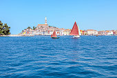 Classic sailboats sail in front of the town of Rovinj