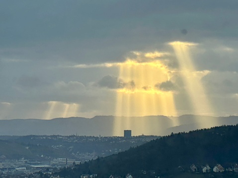 Rays of sunlight shining through a cloudy sky in Stuttgart, Germany