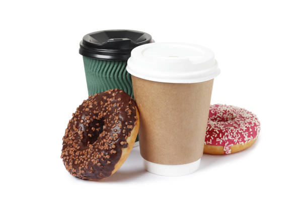 istock Cup of coffee with tasty donuts on white background 1845255262