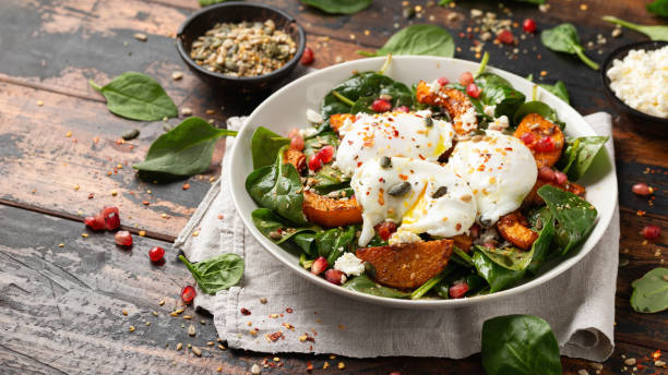 istock Roasted butternut squash salad served with poached eggs, spinach, nuts and pomegranate seeds 1845271629