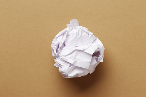 Crumpled paper ball on a colored background